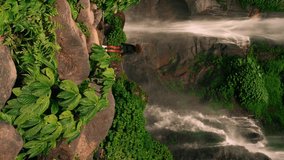 Happy travel people enjoy breathtaking view amazing waterfall hidden in tropical rainforest jungle. 4K 