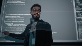 Teacher Giving Computer Science Lecture to Diverse Multiethnic Group of Female and Male Students in Dark College Room. Projecting Slideshow with Programming Code. Explaining Information Technology. - Powered by Shutterstock - Get 15% off with code: PIKWIZARD15