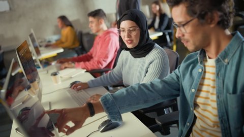 Female Muslim Student Wearing Hijab, Studying in Modern University with Diverse Multiethnic Classmates. She Asks Scholar a Question in College Room. Lecturer Shares Knowledge with Smart Scholars.
