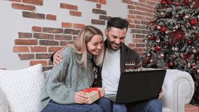 New Year sale time. Satisfied young couple use mobile bank app on laptop pay online for Christmas presents ordered on ecommerce websites. Happy family spend money from credit card buy gifts at web. - Powered by Shutterstock - Get 15% off with code: PIKWIZARD15