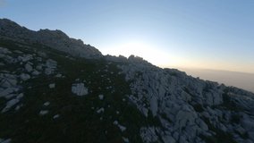 FPV video, mountain surfing, flying at high speed over a granitic mountain range during a beautiful sunrise. Mount Limbara (Monte Limbara) Tempio Pausania, Sardinia, Italy.