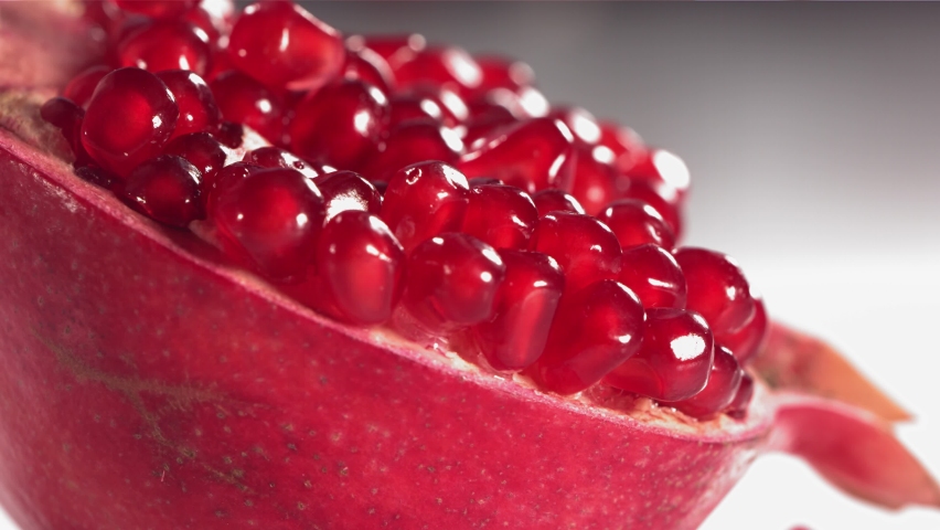 Pomegranate Grains rolls down on surface of broken pomegranate in slow motion Royalty-Free Stock Footage #1081291577