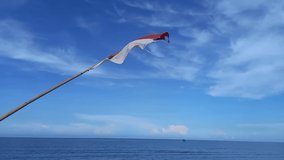Flag of Indonesia waving in the wind on Called Sejarah Beach, Sumatra