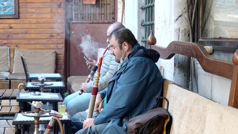 ISTANBUL - OCT 22: Turkish men smoking  a hookah in the morning at an old cafe. Group of men smoking natural water pipes - traditional for Turkey in Istanbul, October 22. 2021 