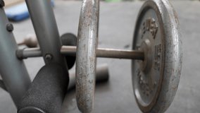 This slow motion video shows a close up view of hands pushing a weight plate on to an exercise machine.