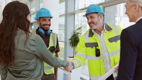Smiling civil engineer and manual worker shaking hands at construction site with happy business women. Construction manager and supervisor shaking hand on building site. Team of workers meeting. - Powered by Shutterstock - Get 15% off with code: PIKWIZARD15