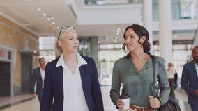 Two business women walking and talking in office. Two successful women manager discussing work while entering office building. Mature business woman talking with her assistant while going to work. - Powered by Shutterstock - Get 15% off with code: PIKWIZARD15