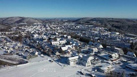 Air video shows the place Winterberg in winter. Snow covers the landscape. In the background are the Rothaar mountains. Real time. 