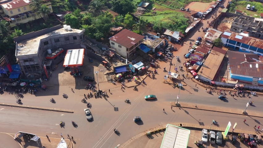 Aerial Freetown Sierra Leone busy intersection mototcycles. West Africa suffers extreme poverty and hunger. Congested crowded homes and businesses. Tropical climate. 
