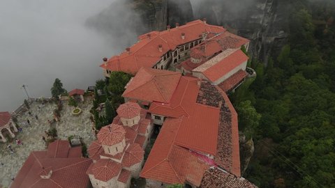 Varlaam Monastery Atop of Cliff, Meteora, Kalambaka, Greece, Aerial View. Unesco World Heritage Site on Foggy Morning, Birdseye Drone Shot