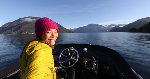 Woman Driving Motor Boat Selfie Video Portrait Looking at Camera Smiling in Beautiful Nature Landscape in British Columbia Near Bute, Toba Inlet, and Campbell River, Vancouver Island, Canada