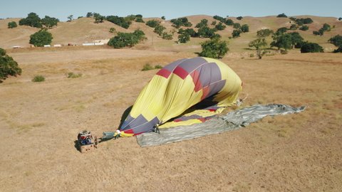 Solvang California USA, June 2019. Deflated hot air balloon after flight on summer sunny vacation day. Cinematic travel 4K tourism concept video. Colorful hot air balloon basket with happy travelers