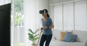 Asia people beautiful young woman wear smart VR goggles enjoy workout with fun laugh on TV at sofa home indoor on AI app. AR sport body build program on IoT social network. Stress relief activity.