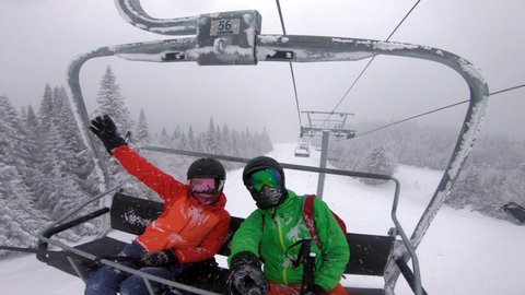 Ski vacation - People in ski lift doing selfie video. Ski winter holidays concept. Skiing on snow slopes in mountains, Couple having fun on a snowy day - Winter sport outdoor activity