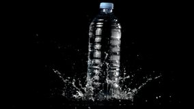Super slow motion water bottle falls on the table with splashes.Filmed on a high-speed camera at 1000 fps. On a black background.  - Powered by Shutterstock - Get 15% off with code: PIKWIZARD15