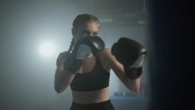 Female fighter trains his punches, beats a punching bag, training day in the boxing gym, the female strikes fast, 4k slow motion. - Powered by Shutterstock - Get 15% off with code: PIKWIZARD15