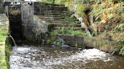 Canal overflow to right water from pipe left lock gates closed Huddersfield Yorkshire England 26-10-2021