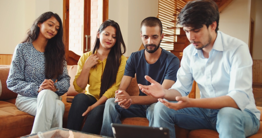 A discussion of Indian friends around the table while looking at the tablet
