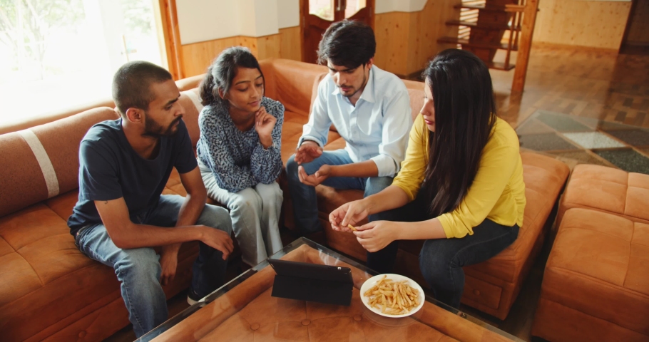 A discussion of Indian friends around the table while looking at the tablet