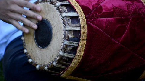 the video is a close up of a musician playing mridangam which is an indian percussion instrument