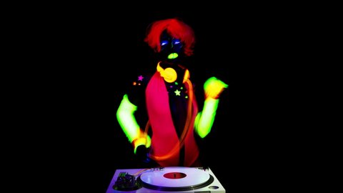 A cool sexy djing woman wearing UV fluorescent clothing and makeup
