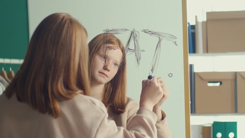 Reflection of a Red haired Teenage Girl Writing an Inscription on a Mirror, Suffering from Anorexia, Bulimia, Eating Disorder. Mental Health.