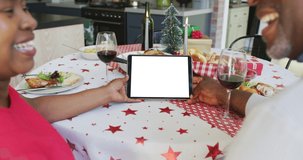 Smiling african american couple making tablet christmas video call, copy space on screen. christmas, festivity and communication technology.