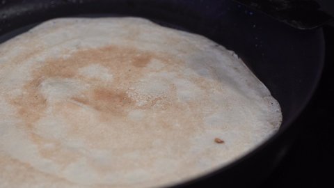 traditional russian thin pancakes called blini preparation on kitchen pan, closeup shot