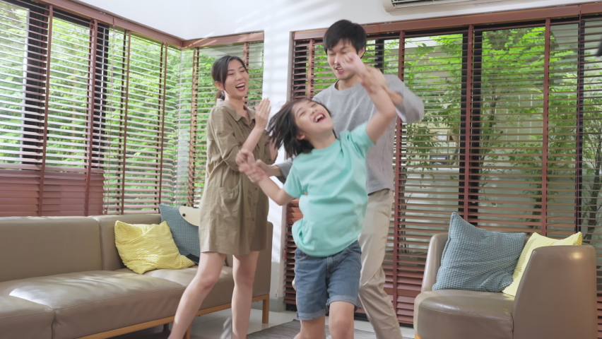 Happiness cheerful asian family dad mom and son funny dancing in living room at home.funny moment dancing at home enjoying holiday together.asian Family spending quality time together concept.