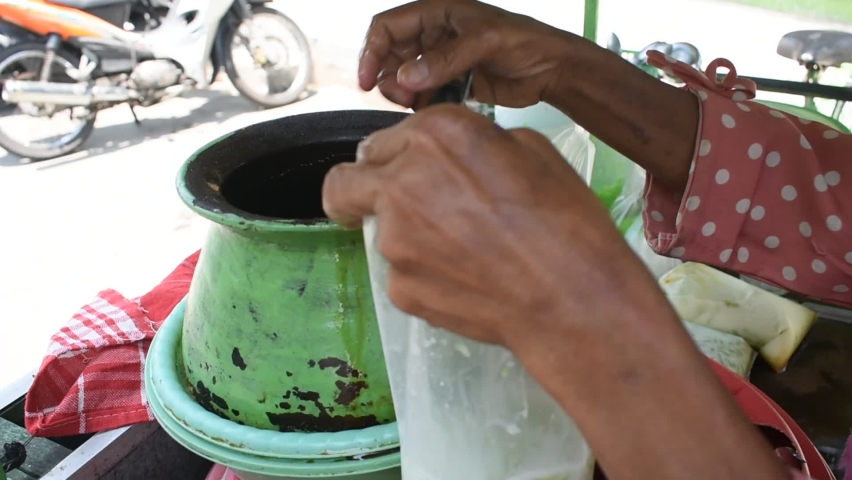 Mixing the drink "Cendol", a traditional Indonesian drink that is green in color with sweet palm sugar.