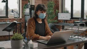 Business woman working with laptop and rate charts during covid 19 pandemic. Startup employee using papers and computer for project planning and data analysis, wearing face mask. - Powered by Shutterstock - Get 15% off with code: PIKWIZARD15