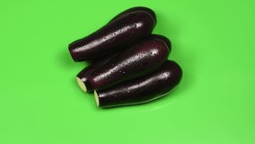 Eggplant on green background. Side view. Loop motion. Rotation 360. 4K UHD video footage 3840X2160