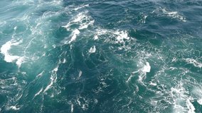 Top view of water surface with whirlpool and tide during summer windy day. Sea or Ocean surface as texture or background, video 4k resolution
