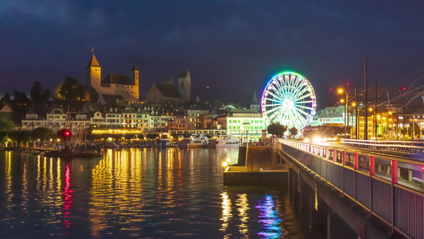 Time lapse, Ferris wheel at night. Observation wheel in medieval european town next to the lake. Rapperswil-Jona, Canton St. Gallen, Switzerland.