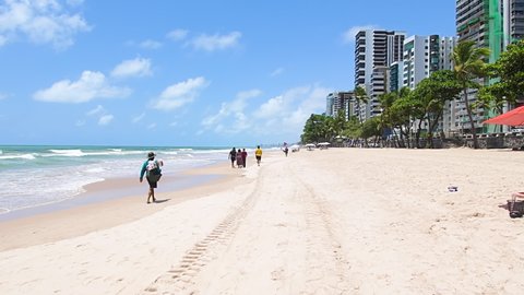 Recife, PE, Brazil - October 14, 2021: Walking at Boa Viagem beach. Beachfront next to the avenue. People enjoying the day at the beach on a beautiful sunny day. 
