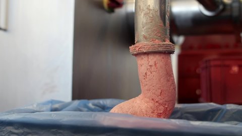 a large meat grinder grinds the meat into a paste