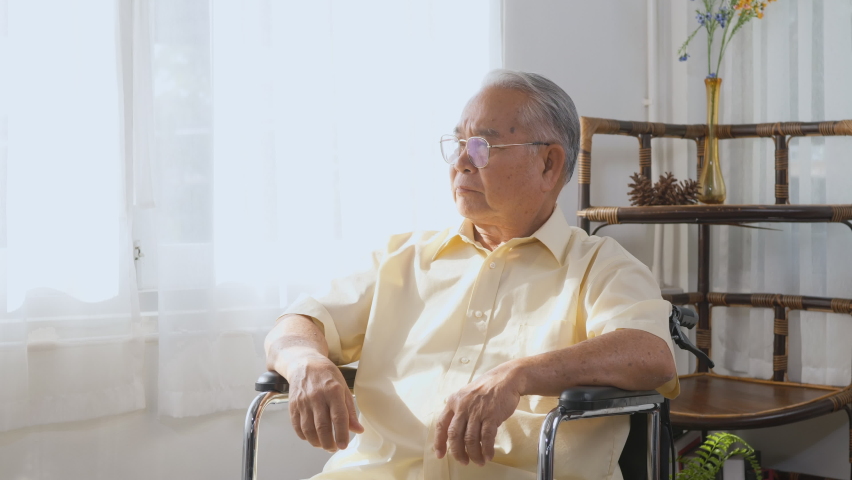 Pensive disabled elderly patient sit on wheelchair alone, Sad and depressed lonely Asian senior old man head down feel lonely and bored waiting for take care white room dementia and Alzheimer | Shutterstock HD Video #1081390457