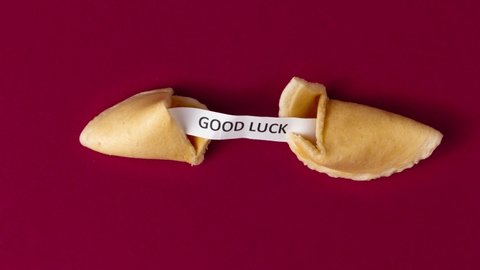 a stopmotion of a fortune cookie cracking and showing a prophecy, saying good luck