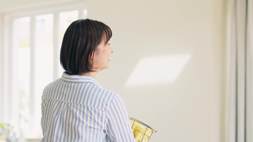 Young asian woman holding a laundry basket.