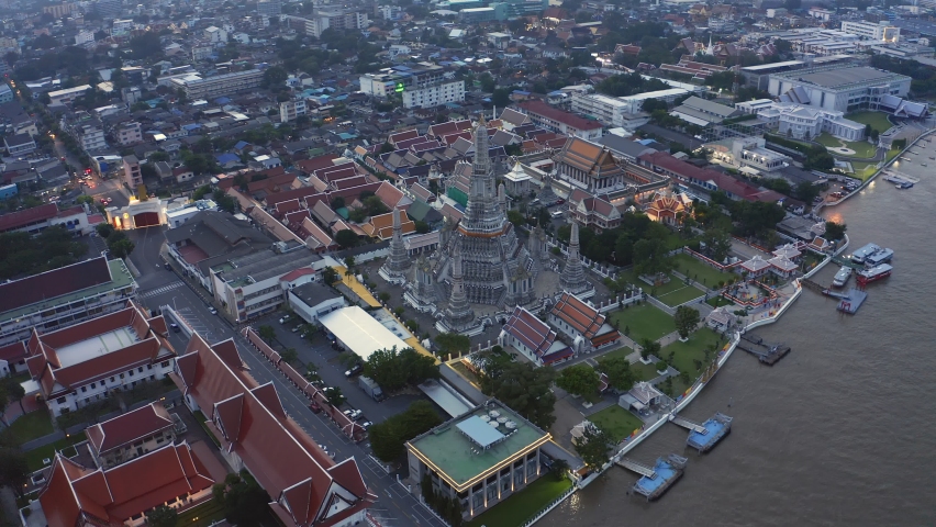 Aerial view Day to Night of Chao Phraya River with wat Arun and Emerald Buddha Temple Landmark of Bangkok, Thailand. Amazing Drone Footage over the City skyline in twilight.