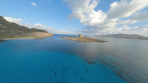 FPV video, view from above, flying at high speed over a turquoise water with a beautiful  white sand beach La Pelosa Beach, Stintino,. Sardinia, Italy.