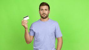 Handsome man happy and holding a credit card over isolated background