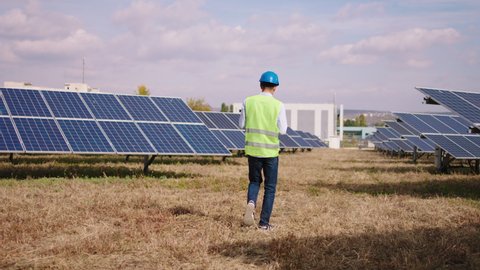 Concept of green energy solar panels park industrial mechanic walking through the photovoltaic batteries and take some information about the solar panels