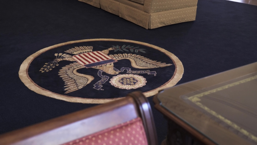 Washington DC - USA - October 10, 2022: The White House Oval Office - View of the Presidential Seal on the carpet inside the Oval Office in Washington DC from the Resolute Desk. 