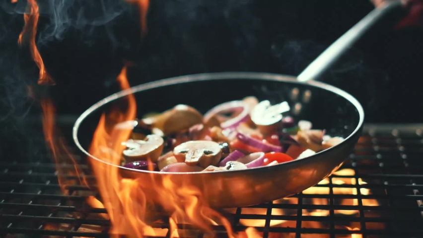 vegetables flying into the pan in slow motion. Onions, broccoli, mushrooms, champignons, tomatoes, zucchini. Healthy vegetarian food. Cooking on fire Royalty-Free Stock Footage #1081416413