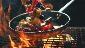 vegetables flying into the pan in slow motion. Onions, broccoli, mushrooms, champignons, tomatoes, zucchini. Healthy vegetarian food. Cooking on fire - Powered by Shutterstock - Get 15% off with code: PIKWIZARD15