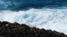 Waves breaking over dangerous rocks, Sea storm concept, Sunny daytime seascape, Devastating and spectacular, ocean waves crash on the rocks of the coast creating an explosion of water, 4k