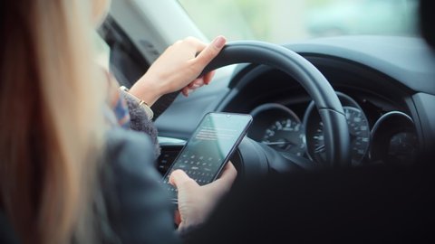 Checking Email Chats And Reading News. Female Writing Message In Vehicle On Social Network Chats On Cellphone. Texting And Driving Car On Social Media. Woman Texting On Smartphone While Driving Car.