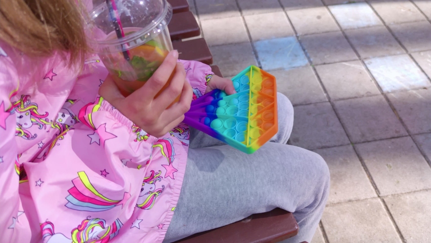 Child with drink and pop it in park slow motion