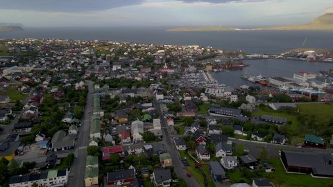 Beautiful cinematic aerial footage of the city of Torshavan in the Faroe Islands and its classic colorful houses, red Goverment building with grass on the roof, and marina